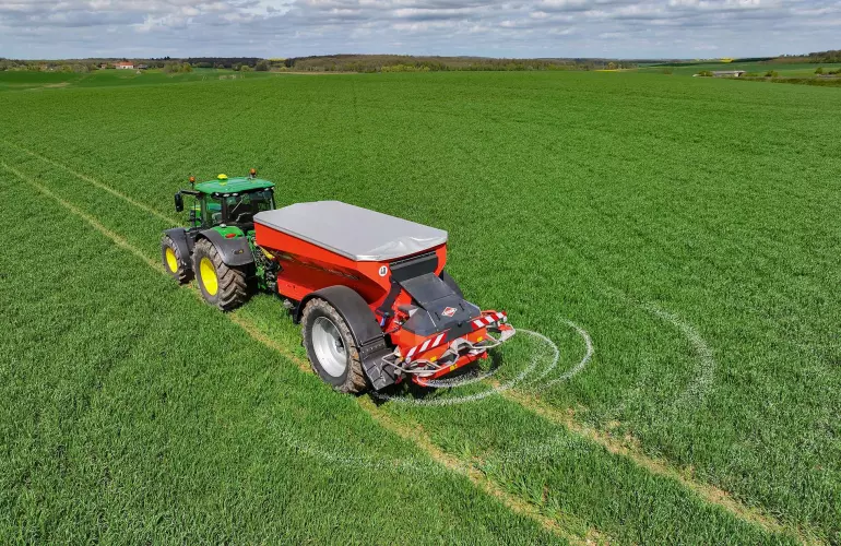 L'épandeur d'engrais traîné AXENT qui distribue l'engrais au champs