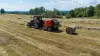 La presse à balles rondes à chambre fixe KUHN FB 3125 en train de presser des balles rondes d'ensilage.